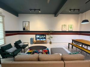 a living room with a couch and a tv at R3troHouse3 4BR 14PAX Near188Tower, HTAA, In Town in Kuantan