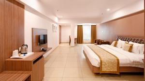 um quarto de hotel com uma cama e uma televisão em Hotel Dwarkamai em Nagpur