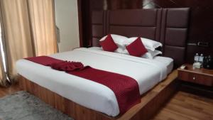 a bedroom with a large white bed with red pillows at Hotel Quick Twenty and Riverside Pvt Ltd in Amlekhganj +14 photos