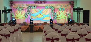 a banquet hall with chairs and a stage with a backdrop at Hotel Quick Twenty and Riverside Pvt Ltd in Amlekhganj