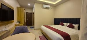 a bedroom with a bed and a chair and a tv at Hotel Quick Twenty and Riverside Pvt Ltd in Amlekhganj