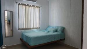 a bed in a room with a window and a mirror at Casita Puerto Maya in Puerto Aventuras