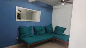 a blue room with a couch with green pillows at Casita Puerto Maya in Puerto Aventuras