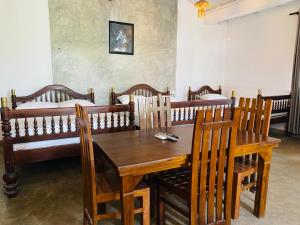 a dining room with a wooden table and chairs at Amadio Beach Resort in Hikkaduwa