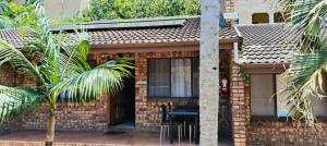 a brick house with a table and chairs in front of it at Flamboyant Apartments in St Lucia