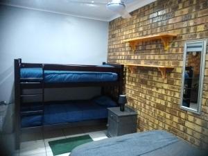 a room with two bunk beds in a brick wall at Flamboyant Apartments in St Lucia +55 photos