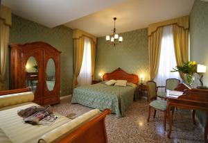 a bedroom with a bed and a desk and a piano at B&B Al Palazzetto in Venice