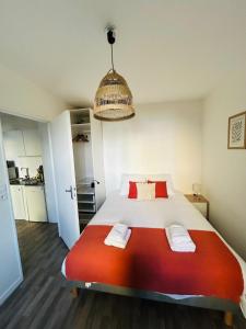 a bedroom with a large white bed with red pillows at Appartement proche université in Caen