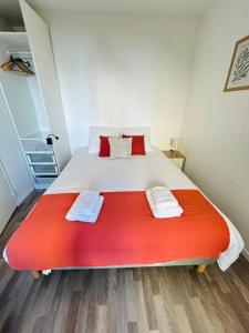a bedroom with a large bed with a red blanket at Appartement proche université in Caen