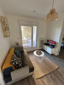 a living room with a couch and a table at Appartement proche université in Caen
