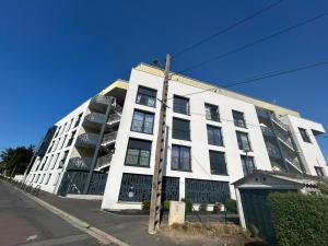 a large white building on the side of a street at Appartement proche université in Caen