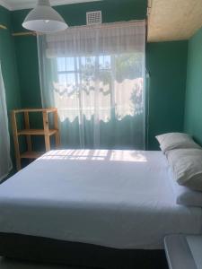 a bedroom with a large bed and a window at Number 5 Beau Rivage in Knysna