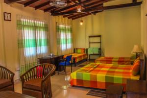 a bedroom with two beds and a table and chairs at Satyodaya Educational Training Centre in Kandy