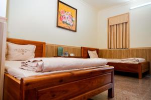a bedroom with two beds and a picture on the wall at Bavieco - Nghỉ dưỡng, Dưỡng lão & Chữa bệnh theo Đông y in Ba Vì