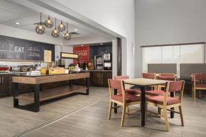 a restaurant with a table and chairs and a counter at Hampton Inn & Suites - Mansfield in Mansfield