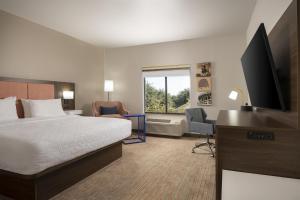 a hotel room with a bed and a flat screen tv at Hampton Inn & Suites - Mansfield in Mansfield