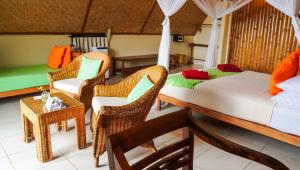 a bedroom with a bed and chairs and a table at Mbeliling Mountain Ecolodge in Noca +23 photos