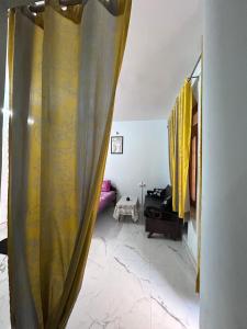 a living room with yellow curtains in a room at Shiva in Hāpur