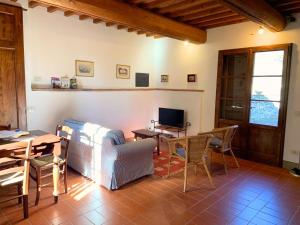 ein Wohnzimmer mit Sofa, Tisch und Fernseher in der Unterkunft Borgo Bottaia in Grassina