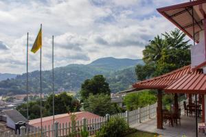 a yellow flag on a building with mountains in the background at Satyodaya Educational Training Centre in Kandy