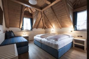 two beds in a room with wooden ceilings and windows at Residence Villa Stella in Ortisei +72 photos