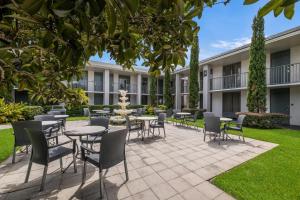 a courtyard with tables and chairs and a fountain at Clarion Inn & Suites Across From Universal Orlando Resort in Orlando