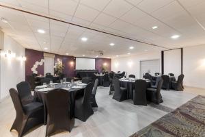 a conference room with black tables and chairs at Clarion Inn & Suites Across From Universal Orlando Resort in Orlando +58 photos