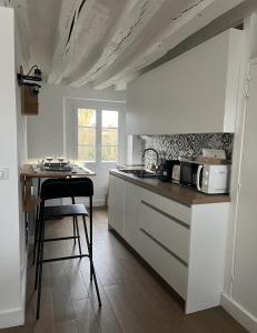 a kitchen with a counter and a table with a microwave at La Suite Bellifontaine in Fontainebleau