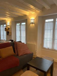 a living room with a couch and a table at La Suite Bellifontaine in Fontainebleau