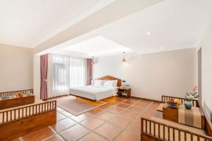 a bedroom with a white bed in a room at 赛家花园酒店SAI JIA Garden HOTEL in Dali Ancient Town