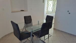 a glass table with four black chairs around it at Biserka hidden gem of the island Hvar in Pitve +15 photos