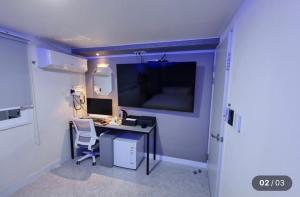 a room with a desk with a computer and a monitor at Hotel Social Stay in Pocheon