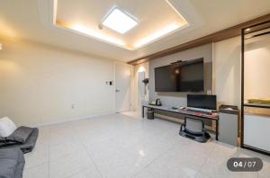 a large living room with a television and a desk at Hotel Social Stay in Pocheon