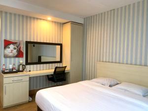 a bedroom with a bed and a desk and a mirror at Wisma Lovebird in Kalianget +60 photos