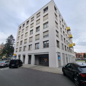 a white building with cars parked in front of it at Apartament Skarbowa West in Leszno