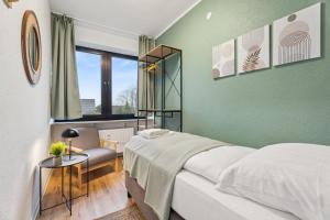 a green bedroom with a bed and a chair at Sali-Homes Monteur Stay in Kleve