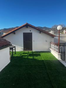 a white house with a yard with a green lawn at Terrazza Belvedere Sanremo in Sanremo