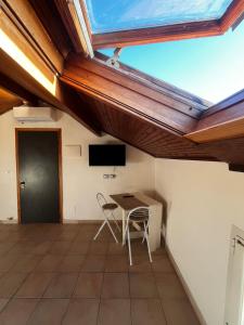 a room with a table and chairs and a skylight at Terrazza Belvedere Sanremo in Sanremo