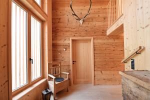 a hallway of a log cabin with a chair and a window at UNSER VORSÄSS - Geißkopf in Schwarzenberg +37 photos