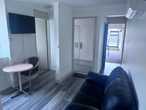 a living room with a couch and a table at Citigate Motel Newcastle in Newcastle