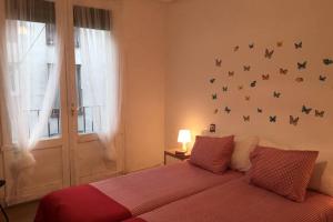 ein Schlafzimmer mit einem Bett mit Schmetterlingen an der Wand in der Unterkunft Apartamentos Coso in Saragossa