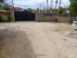 a dirt parking lot with a fence and a car at Serena10 in Mombasa