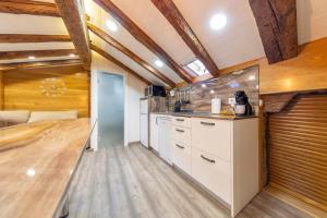 a kitchen with white cabinets and a wooden floor at Cozy Attic in the City Center of Soria in Soria