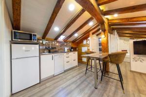 a kitchen with a white refrigerator and a table at Cozy Attic in the City Center of Soria in Soria +32 photos