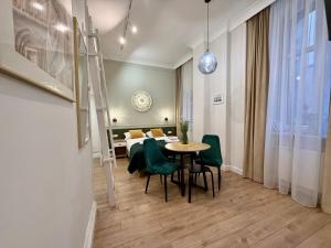 a dining room with a table and green chairs at Apartamenty Katarzynki by Rentoom in Toruń