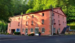 a large orange building with trees in the background at Chabanettes Hotel & Spa in Auzelles