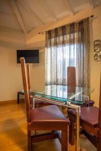 a dining room with a glass table and chairs at Bed and Breakfast La Panarda in Subiaco