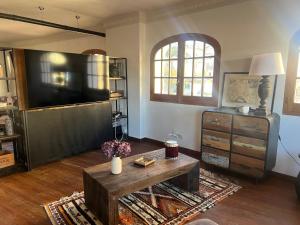 a living room with a large television and a coffee table at Séjour Royal in Xàtiva