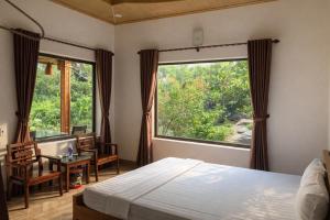 a bedroom with a bed and a large window at Trang An ViewPoint Homestay in Ninh Binh