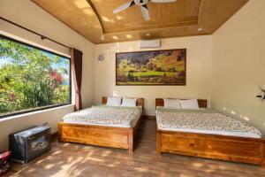two beds in a room with a window at Trang An ViewPoint Homestay in Ninh Binh +126 photos